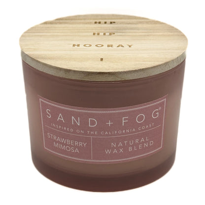 Strawberry Mimosa candle with wooden lid labeled 'Sand + Fog' on a white background