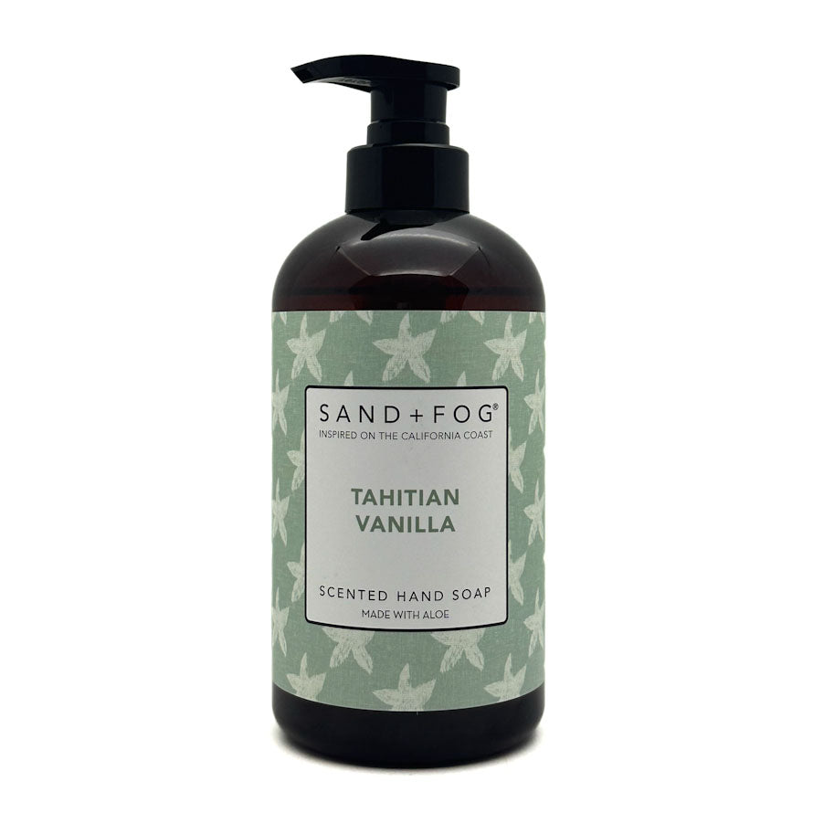 A bottle of Sand + Fog Tahitian Vanilla Scented Hand Soap. The product is in a dark amber-brown bottle with a black pump dispenser, featuring a light green label with white starfish patterns and a white central label.