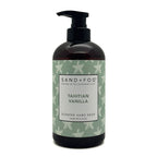 A bottle of Sand + Fog Tahitian Vanilla Scented Hand Soap. The product is in a dark amber-brown bottle with a black pump dispenser, featuring a light green label with white starfish patterns and a white central label.