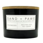 Teakwood black candle with a wooden lid and 'Sand + Paws' label on a white background