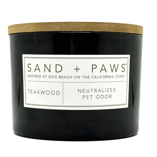Teakwood black candle with a wooden lid and 'Sand + Paws' label on a white background