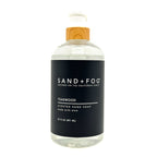 Teakwood clear bottle hand soap with a black label featuring 'Sand + Fog' on a white background.