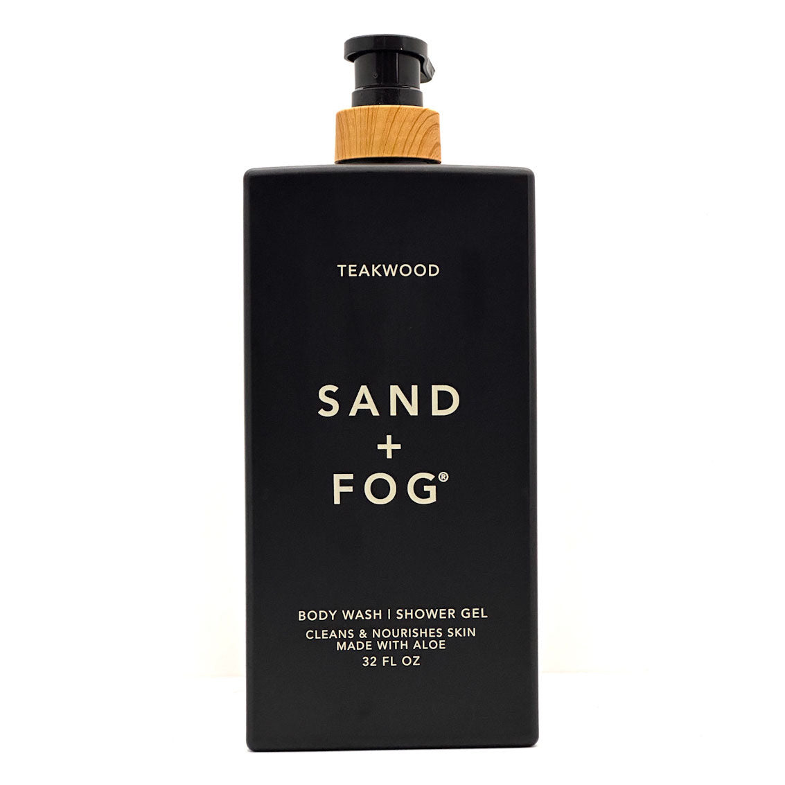 A 12 fl oz black bottle of Sand + Fog Teakwood body wash and shower gel with a light wood-textured collar and gold lettering, shown on a white background.