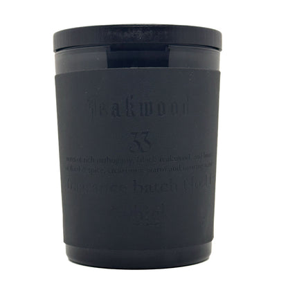 A matte black candle jar with a matching lid, featuring embossed text that reads 'Teakwood 33' on a clean white background.