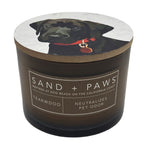 Teakwood candle with a dog illustration on the lid and 'Sand + Paws' branding.