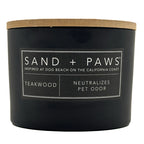Teakwood Black candle with a wooden lid labeled 'Sand + Paws' on a white background