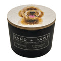 Teakwood Candle with a dog illustration on the lid and 'Sand + Paws' branding.