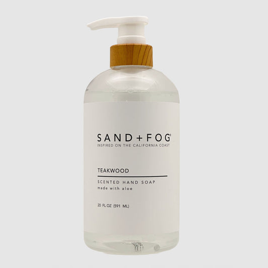 Clear SAND + FOG Teakwood hand soap bottle with pump and wooden top on a light grey background