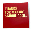 A square red greeting card with metallic gold foil text that reads 'THANKS FOR MAKING SCHOOL COOL.' on a clean white background.
