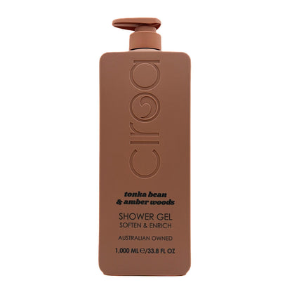 A 1000 mL bottle of Ciroa shower gel in the 'tonka bean & amber woods' scent. The bottle is a matte, warm brown colour with a matching brown pump dispenser on top.