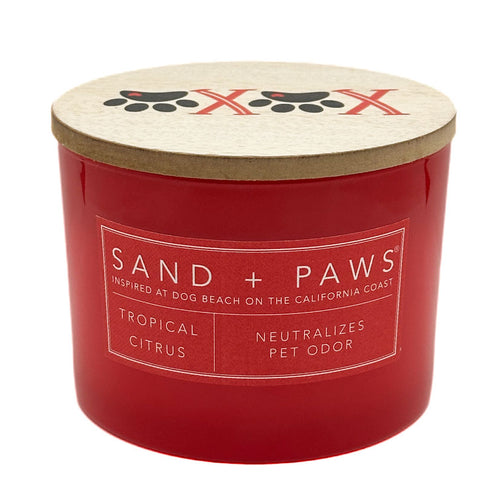 Red Tropical Citrus candle with 'Sand + Paws' branding on a white background
