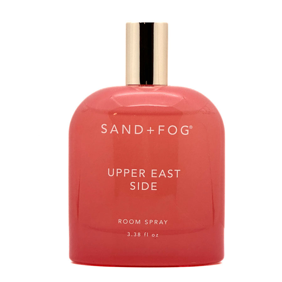 Red room spray bottle labeled 'Sand + Fog Upper East Side' on a white background
