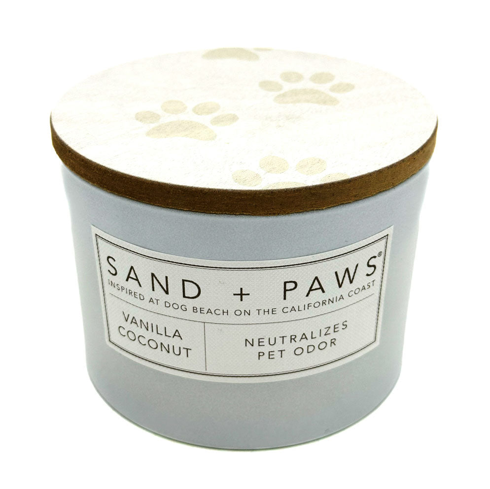 SAND + FOG vanilla coconut candle labeled 'Sand + Paws' with paw print design on lid against a white background