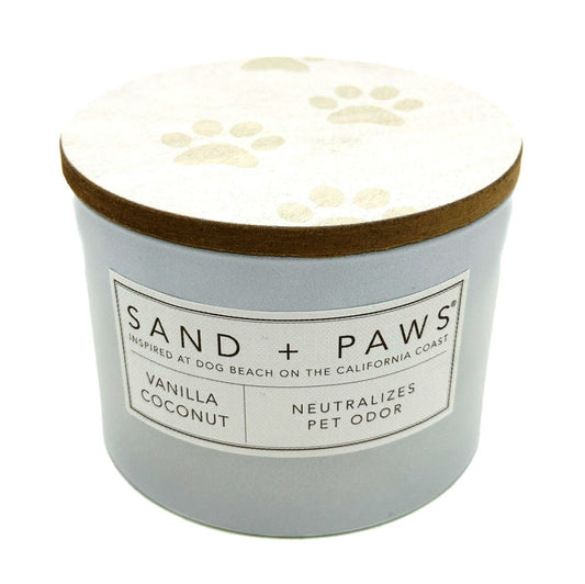 SAND + FOG vanilla coconut candle labeled 'Sand + Paws' with paw print design on lid against a white background