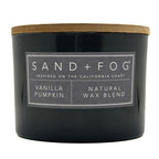 Grey vanilla pumpkin candle with a wooden lid and 'Sand + Fog' label on a white background