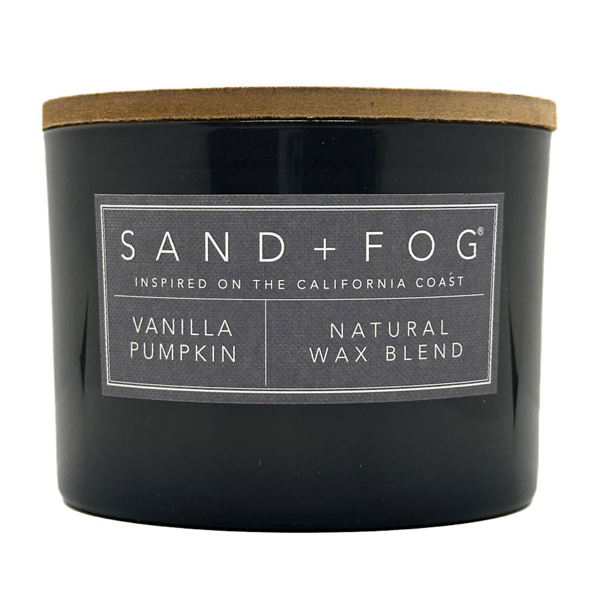 Grey vanilla pumpkin candle with a wooden lid and 'Sand + Fog' label on a white background