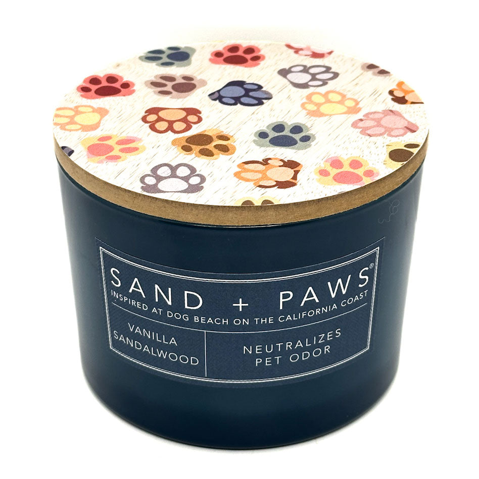 Vanilla Sandalwood candle with 'Sand + Paws' branding and paw print design on the lid.