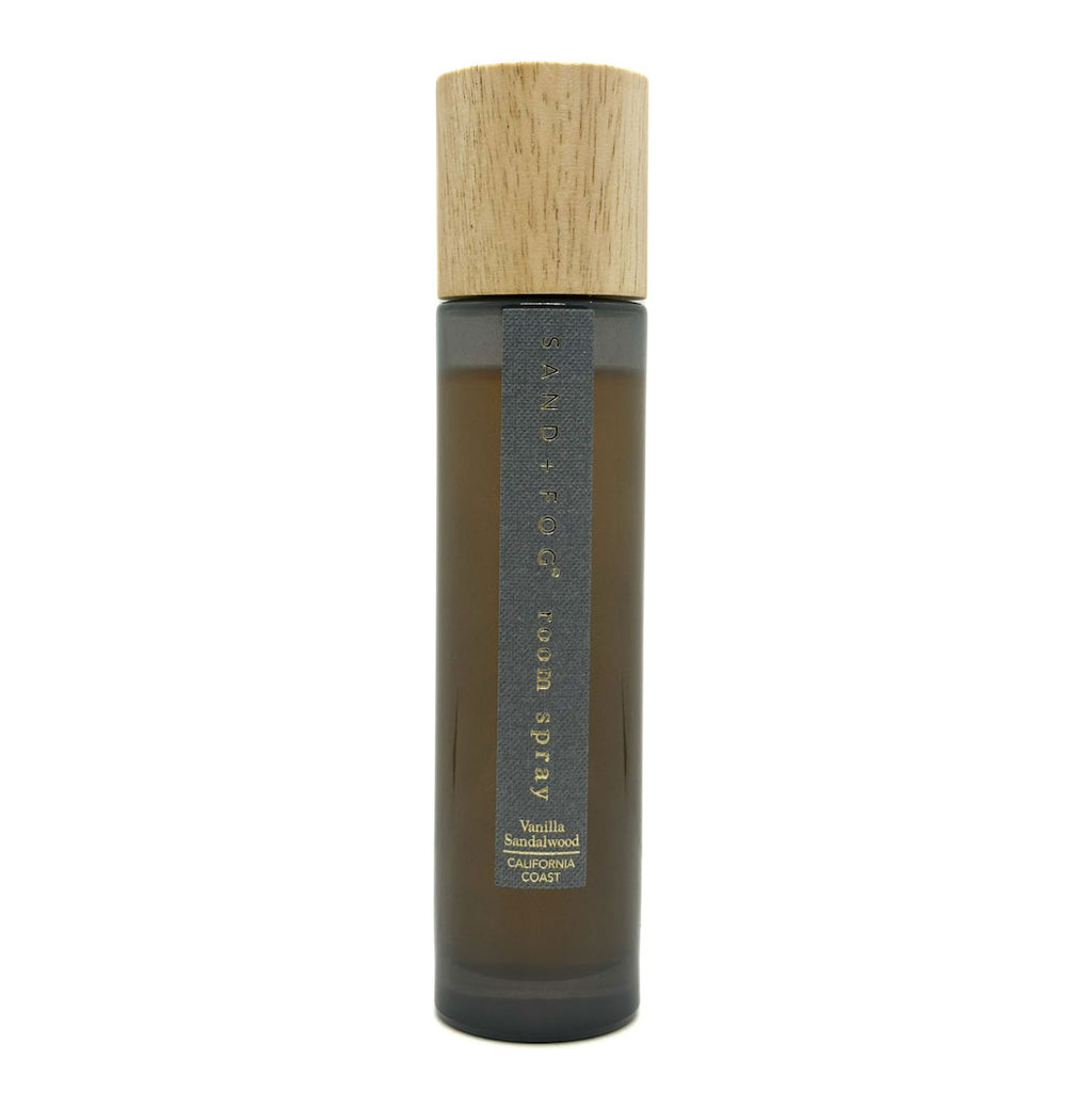 Bottle of Vanilla Sandalwood room spray with a wooden cap on a white background