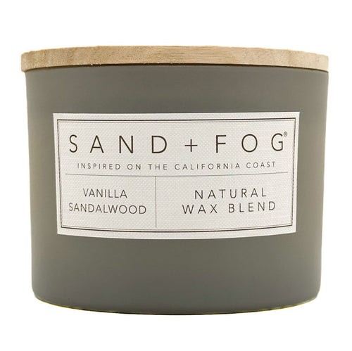 Gray Vanilla Sandalwood candle with a wooden lid and 'Sand + Fog' label on a white background