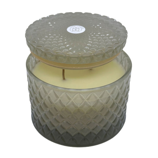 Vanilla Sandalwood decorative candle by SAND + FOG in a textured glass jar with a lid on a white background