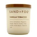 Candle jar labeled 'Sand + Fog Vanilla Tobacco' with a gold lid on a white background