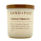Candle jar labeled 'Sand + Fog Vanilla Tobacco' with a gold lid on a white background