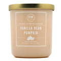 A DW Home Vanilla Bean Pumpkin scented candle in a matte beige jar with a metallic gold lid and a white label.