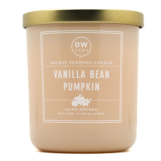 A DW Home Vanilla Bean Pumpkin scented candle in a matte beige jar with a metallic gold lid and a white label.