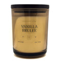 DW Home Vanilla Brulee candle in a clear container with a black lid on a white background