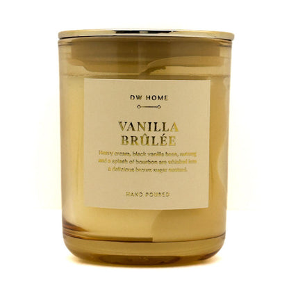A glass jar Mini candle with a gold-toned lid and a cream-colored label reading 'DW HOME VANILLA BRÜLÉE'. The candle is photographed on a clean white background.