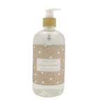A clear pump bottle of Sand+Fog Vanilla Coconut hand wash with a beige burlap-style label featuring white polka dots and a white pump dispenser.