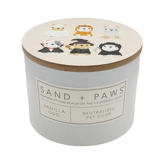 A pet odour neutralising candle in a white cylindrical jar with a light wood lid. The lid features cartoon illustrations of six dogs in different outfits.