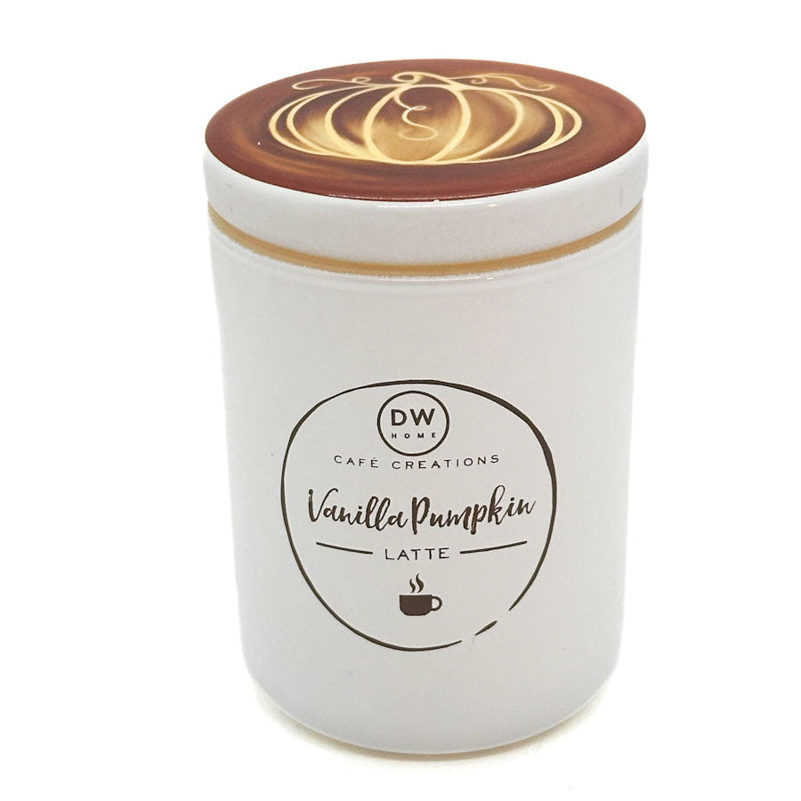 A white ceramic jar candle with a brown lid featuring a gold latte art pumpkin design. The front label reads 'DW Cafe Creations Vanilla Pumpkin Latte'.