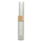 A cylindrical bottle of Vanilla Reserve Sand + Fog reed diffuer with a light wood cap, set against a plain white background.