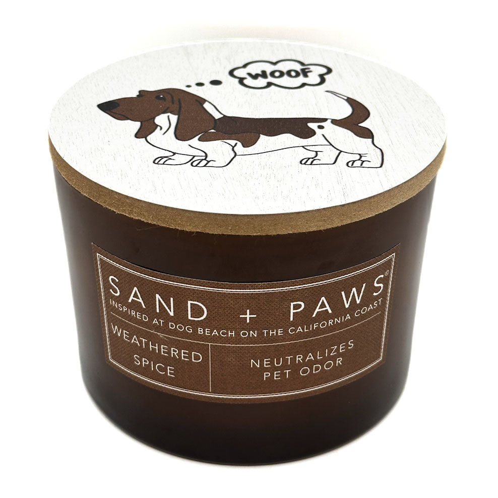 Weathered Spice Candle labeled 'Sand + Paws' with a dog illustration on a white background