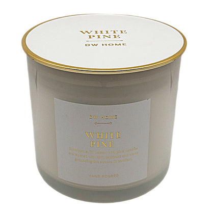 A DW Home White Pine scented candle in a frosted glass jar with a white lid and gold trim, featuring a white label with gold lettering.