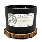 BlackWinter Pine candle with 'Sand + Fog' label on a white background