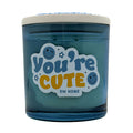 Blue candle jar with 'You're Cute' text and DW Home logo on a white background